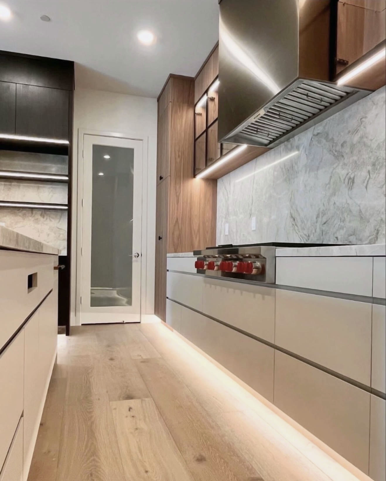 Modern walnut kitchen with marble slab backsplash — St. Louis remodel by Phoenix Construction Group