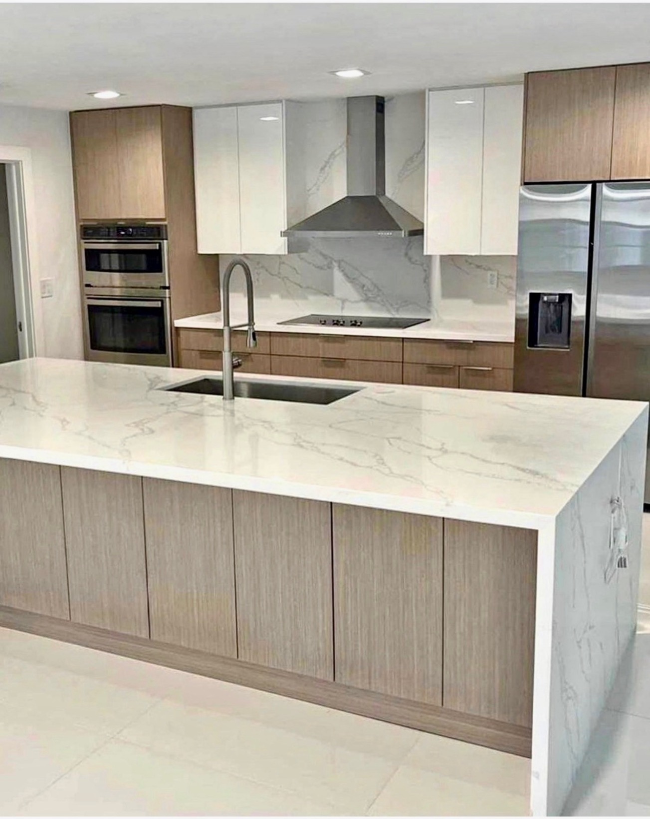 Modern two-tone kitchen with gloss white uppers, wood lowers and marble waterfall island — St. Louis remodel by Phoenix Construction Group